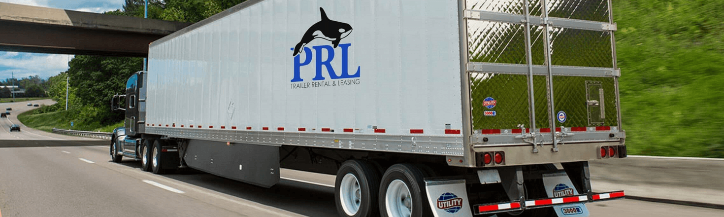 A semi truck pulling a PRL Trailer Rental & Leasing semi trailer on a sunny highway bordered by …